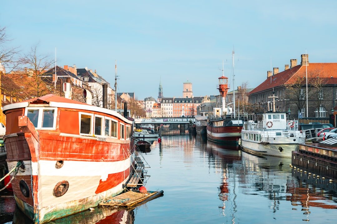 Elderly Danish fisherman standing by his boat in a harbour