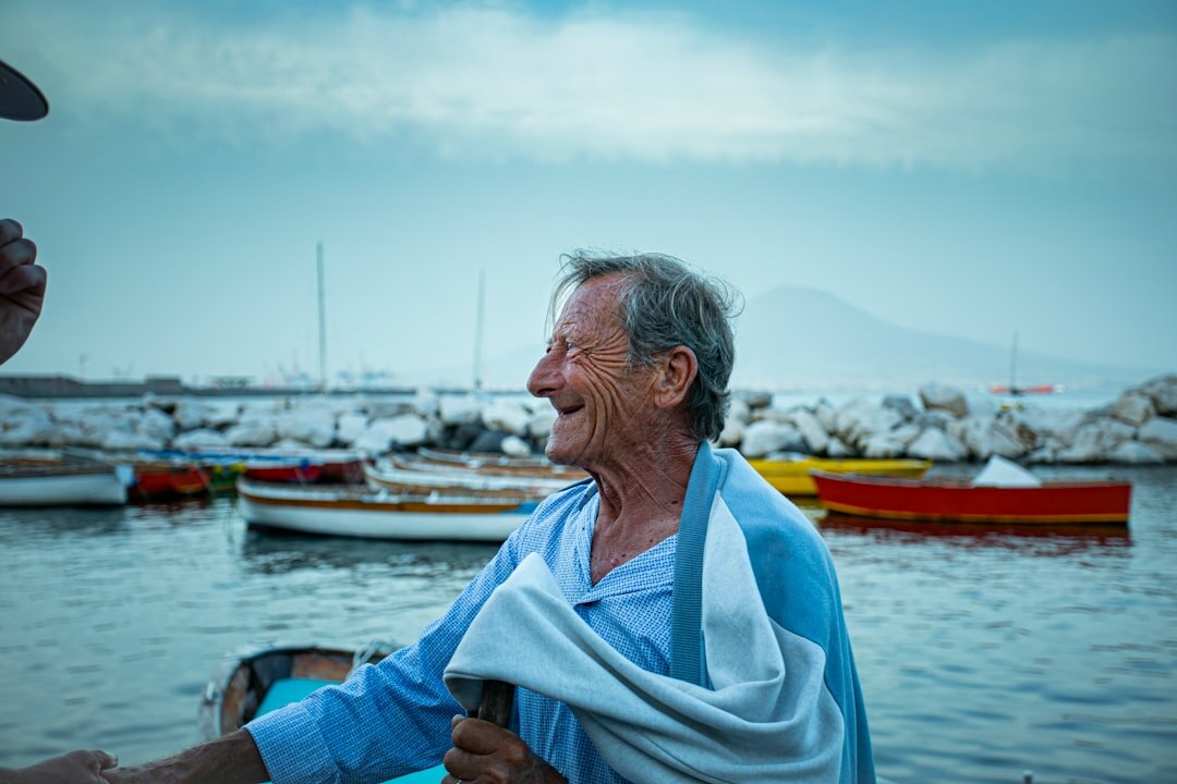 elderly fisherman by sea